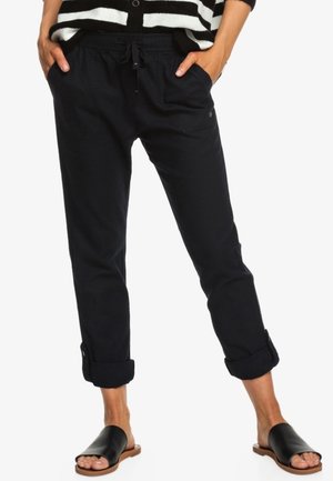 Pantalon bleu marine, coupe décontractée, avec taille à cordon de serrage, deux poches latérales et ourlets retroussés. Tissu doux avec une texture lisse.