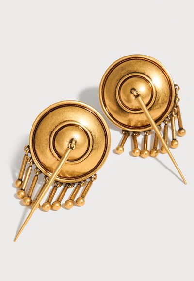 Στρογγυλά σκουλαρίκια σε χρυσή απόχρωση με σχεδιασμό συγκεντρικών κύκλων, το καθένα με μια μακριά καρφίτσα και επτά μικρές κρεμαστές ράβδους που καταλήγουν σε μικρές σφαίρες.