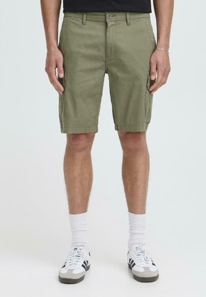 Kaki cargoshorts met een normale pasvorm, van katoen, met zijzakken en een enkele knoopsluiting. Gecombineerd met witte sokken en sneakers.