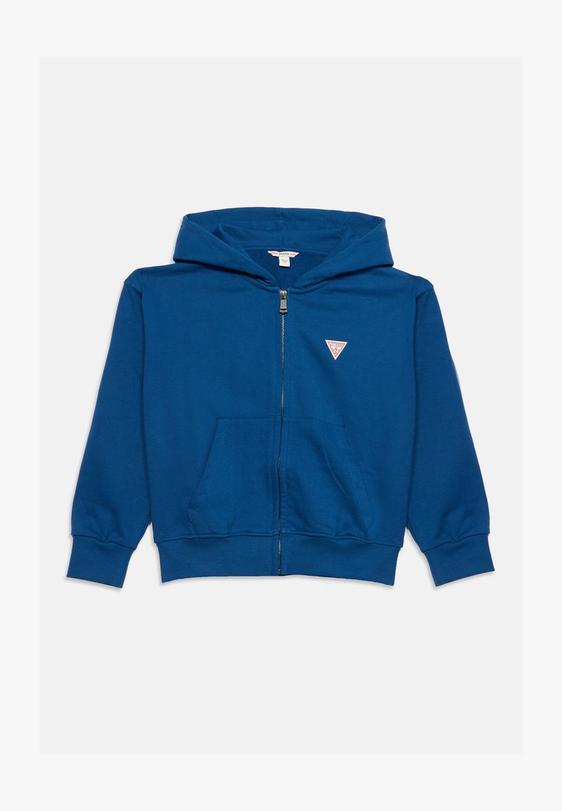 Sweat à capuche bleu zippé avec poches avant et petit logo triangulaire Guess sur la poitrine gauche.
