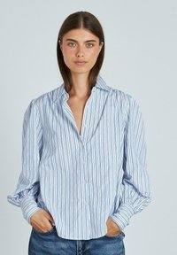 Langdurige overhemd met lange mouwen, uitgerust met blauw-witte verticale strepen en kleine accenten. Gemaakt van lichtgewicht stof, met een relaxte pasvorm en kraag.