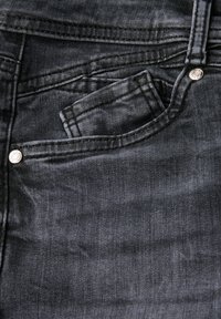 Jeans de denim oscuro con un acabado de lavado claro, que presentan un bolsillo delantero, herrajes de botón plateados y costuras detalladas.
