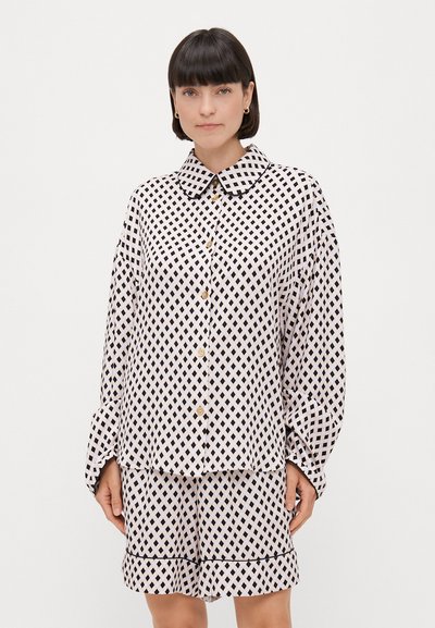 Ensemble chemise boutonnée et short avec un motif quadrillé noir et blanc, comprenant un col, des manches longues et de subtils boutons dorés.