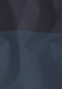 Tissu présentant un design bicolore, avec une section supérieure bleu marine foncé et une section inférieure bleu marine plus claire. La texture semble lisse et durable.