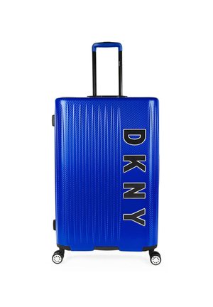 Maleta dura azul con estrías verticales, asa negra, logo de DKNY en letras blancas en negrita y cuatro ruedas giratorias.