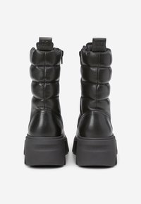 Schwarze Leder-Ankle-Boots mit gepolstertem Design, Reißverschluss hinten und dicker Gummisohle. Geprägtes Logo an der Ferse. Glatte Textur, keine Muster.