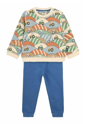 Cotton sweatshirt with multicolored tractor print, cream base. Paired with blue cotton joggers. Features ribbed cuffs and waistband.