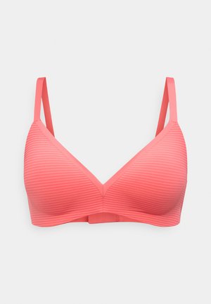 Sujeción inalámbrica rosa coral con tirantes finos ajustables y textura sutilmente acanalada horizontal en las copas, mostrada sobre un fondo neutro.