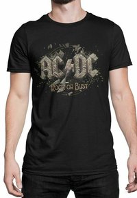 Svart bomull t-skjorte med et slitt AC/DC grafikk og "Rock or Bust" tekst, satt mot et sølvdrysset design, kortermet.