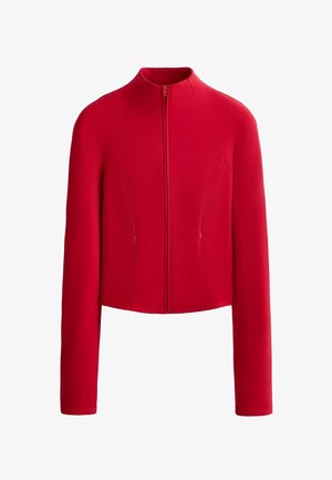 Jachetă lungă roșie cu mâneci lungi, fermoar frontal, guler rotund înalt și două buzunare verticale cu fermoar în față.