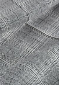 Tissu gris avec une surface texturée et tissée présentant un motif à carreaux subtil dans des nuances plus foncées de gris et des fils blancs.