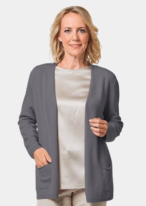 Cardigan gris avec un devant ouvert, des manches longues et deux poches avant. Texture douce et coupe décontractée sur un haut léger et soyeux.