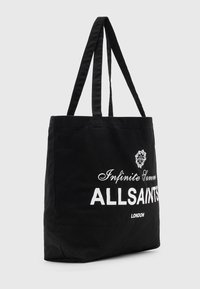Borsa tote nera in tela con manici doppi. Presenta la scritta bianca stampata "Estate Infinita" e "ALLSAINTS LONDON". Design semplice e rettangolare.