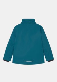 Teal vattentät jacka med hög krage, långa ärmar och elastiska muddar. Reflexrand på baksidan för ökad synlighet. Slät textur.