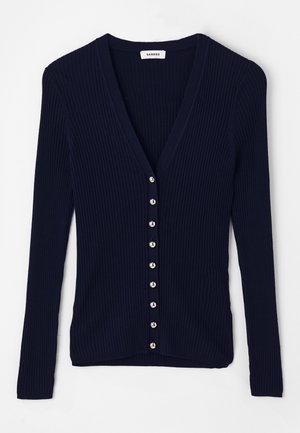 Marineblauwe geribde cardigan met een V-hals, lange mouwen en acht zilverkleurige knopen aan de voorkant. Zachte gebreide textuur.