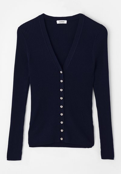 Navy krāsas ribota kardigāna jakas ar V veida kakla izgriezumu, garām piedurknēm un astoņiem sudraba toņu pogām priekšā. Mīksta dzijas tekstūra.