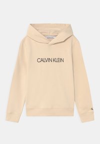 Sudadera con capucha beige hecha de material suave, con un bolsillo tipo canguro, puños acanalados y el logo "CALVIN KLEIN" impreso en letras oscuras en la parte delantera.