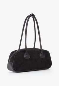 Borsa in suede nera con accenti in pelle liscia, forma arrotondata, manici doppi e dettaglio in zip argentato lungo la cucitura.