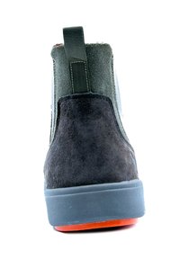 Stivaletto in camoscio nero con suola in gomma grigia. Presenta pannelli laterali elastici e un tassello sul retro per facilitare l'indossamento.