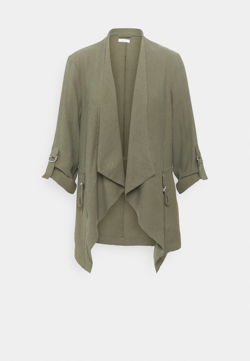 Veste vert olive à ouverture frontale avec revers drapés et manches retroussées maintenues par des pattes boutonnées.