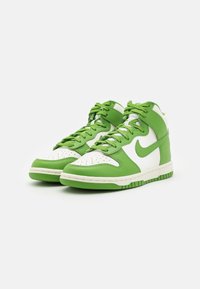High-top sneakers featuring a white and bright green leather design, perforated toe box, green laces, and rubber sole with textured grip.