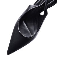 Scarpa nera con punta affilata, realizzata in pelle liscia, con lati aperti e silhouette slanciata. La suola è piatta e presenta una minima ferramenta visibile.