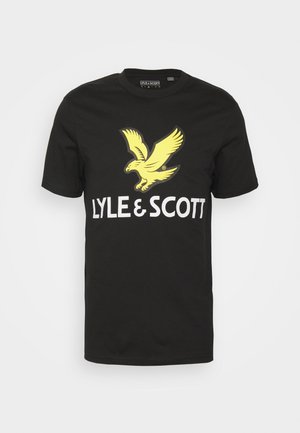 Musta puuvillainen t-paita, jossa suuri keltainen kotka-kuva ja valkoinen "LYLE & SCOTT" -teksti. Klassinen pyöreä kaula-aukko ja lyhyet hihat.
