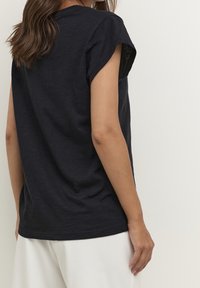 Marinfärgad t-shirt med korta ärmar i lätt tyg, med en avslappnad passform, rullade ärmslut och rundad halsringning.