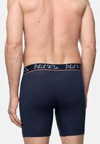 Mörkblå boxershorts med elastisk midja, försedd med vit "Phil & Co." logotyp och röd accentlinje, tillverkade av mjukt bomullsmaterial.