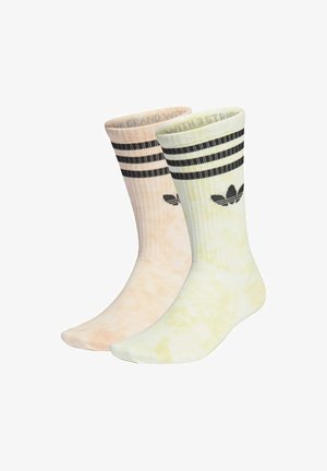 Calzini di cotone con un motivo tie-dye, uno pesca chiaro e l'altro giallo pallido, con righe nere e logo.