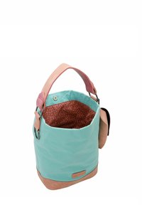 Sac seau en tissu turquoise avec une poignée en cuir rose. L'intérieur présente un motif à pois marron et une poche zippée pour l'organisation.