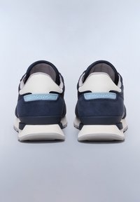 Baskets bleu marine en matière daim et mesh, avec un capuchon de talon blanc et un accent logo. Semelle en caoutchouc épaisse avec un motif.