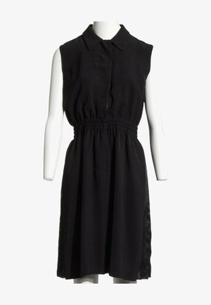 Robe noire sans manches avec col et taille élastique, présentée sur un torse de mannequin blanc sur fond blanc.