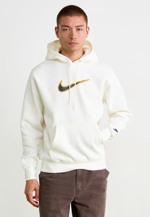 Bela Nike kapuca z velikim črnim in rumenim logotipom. Ima kenguru žep in nastavljivo kapuco z vrvico. Mehka tkanina.