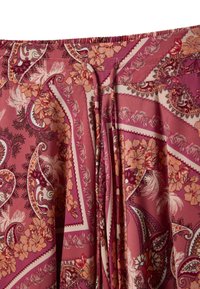 Tela con cintura de cordón con estampados paisley y florales en rosa, púrpura y durazno sobre un material suave y ligero.