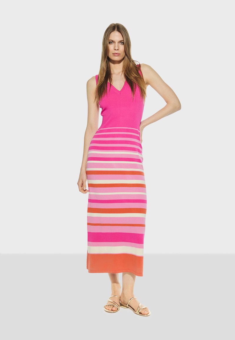 Ružičasta haljina bez rukava s v-izrezom, koja ima horizontalne pruge u nijansama ružičaste, narančaste i kreme, završava tik iznad članka.