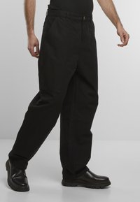 Fekete cargo nadrág egyenes szabású dizájnnal, elülső zsebekkel, gombos záródással és sima pamutszerkezettel. Vastag gumitalpú bakancsok.