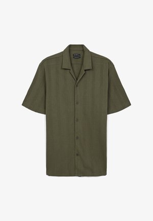Camicia a maniche corte di colore verde oliva realizzata in tessuto texturizzato, con bottone frontale, colletto a punta e sottili righe verticali.