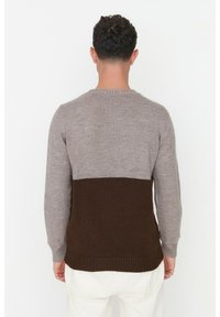 Maglione con parte superiore grigia e parte inferiore marrone scuro. Realizzato in morbido materiale lavorato a maglia con texture, con orlo a coste e maniche lunghe.