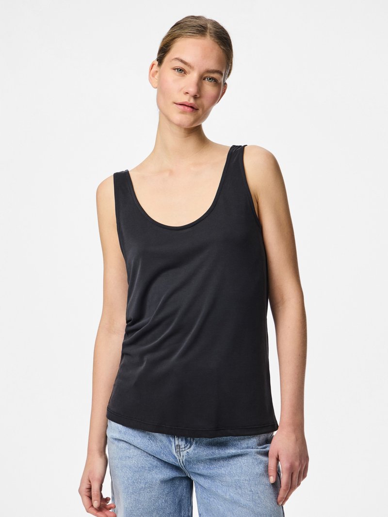 Juoda be rankovių palaidinė su plačiu apvaliu iškirpimu, minkšta tekstūra ir laisvo silueto. Derinama su šviesiai mėlynais aukšto liemens džinsais.