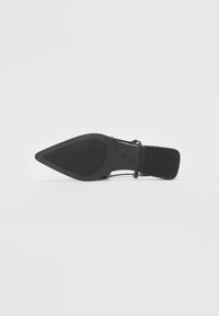 Sorte spisse sko med teksturert gummisåle, tynn stropp og justerbar spenne, med et elegant design og minimalistisk utstyr.