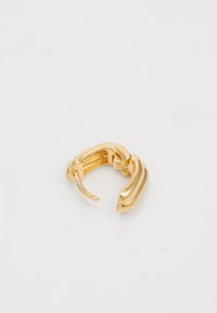 Boucle d'oreille en métal doré avec un design courbé et rainuré. Texture lisse avec une finition brillante. Comprend un détail de marque gravé à l'intérieur.