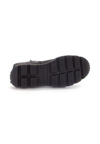 Zwarte rubberen zool van een schoen met diepe groeven, met gestructureerde ribbels en een logo. De zool biedt grip en duurzaamheid voor verschillende terreinen.