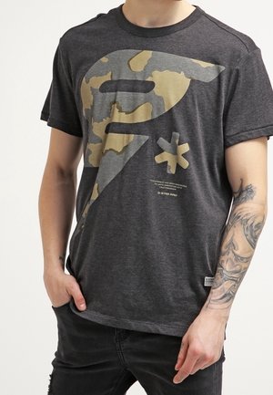 Tmavě šedé bavlněné tričko s velkým béžovým a šedým maskáčovým potiskem a logem na přední straně. Kulatý výstřih a krátké rukávy.