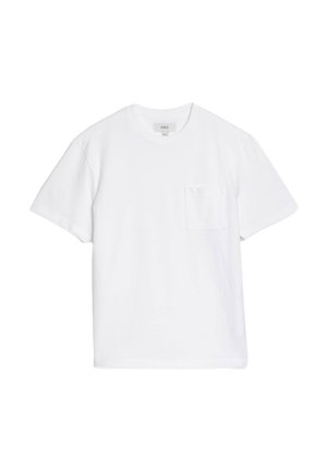 Vit bomulls t-shirt med rund hals, korta ärmar och en bröstficka på vänster sida. Mjuk textur med en avslappnad passform.