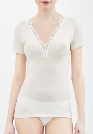 Top corto bianco a maniche corte con scollatura a V profonda e bordo in pizzo. Tessuto morbido e liscio con silhouette aderente, ideale per stratificare.