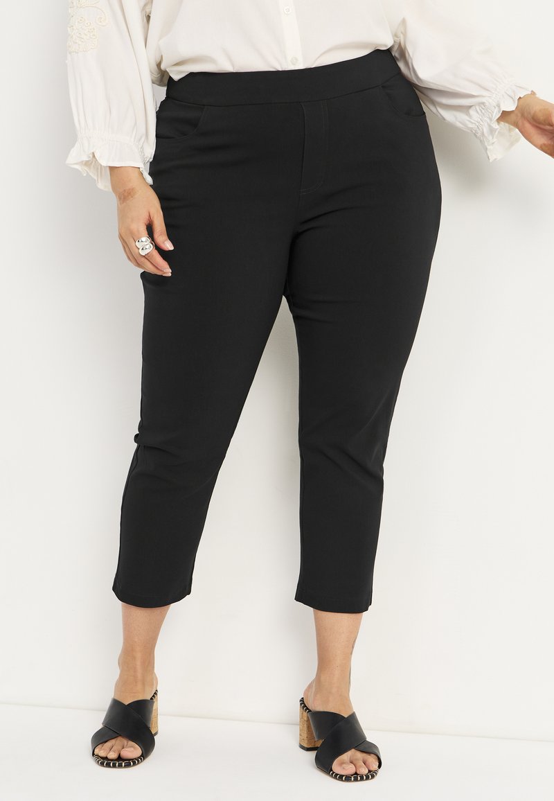 Zwarte cropped broek met een gladde textuur, een middelhoog taille en twee zijzakken. Draag het met zwarte hakken met kruisbanden en een kurken hak.