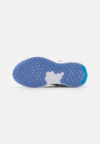 Suela de zapato con un patrón azul y blanco, goma texturizada para tracción, con dibujos de treads circulares y ovalados. Logo de Nike contorneado en blanco.