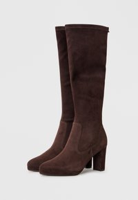 Brown suede knee-high boots with a square toe and block heel. Smooth texture with side elastic panels for a fitted look.