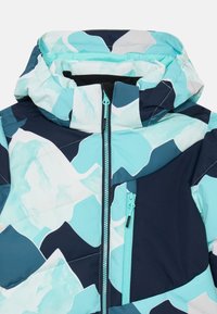 Μπουφάν με επένδυση που διαθέτει γεωμετρικό σχέδιο σε ανοιχτό μπλε, σκούρο μπλε και λευκό. Κουκούλα με φερμ�ουάρ και πλαϊκή τσέπη με αντίστοιχο φερμουάρ.